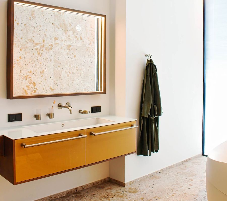 Modernes Badezimmer mit Holzrahmenspiegel und Naturstein, individuell entworfen von Tischlerei Gangl.