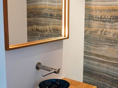 Stilvolles Badezimmer mit Holzwaschtisch und Designer-Spiegel, individuell gestaltet von Tischlerei Gangl.